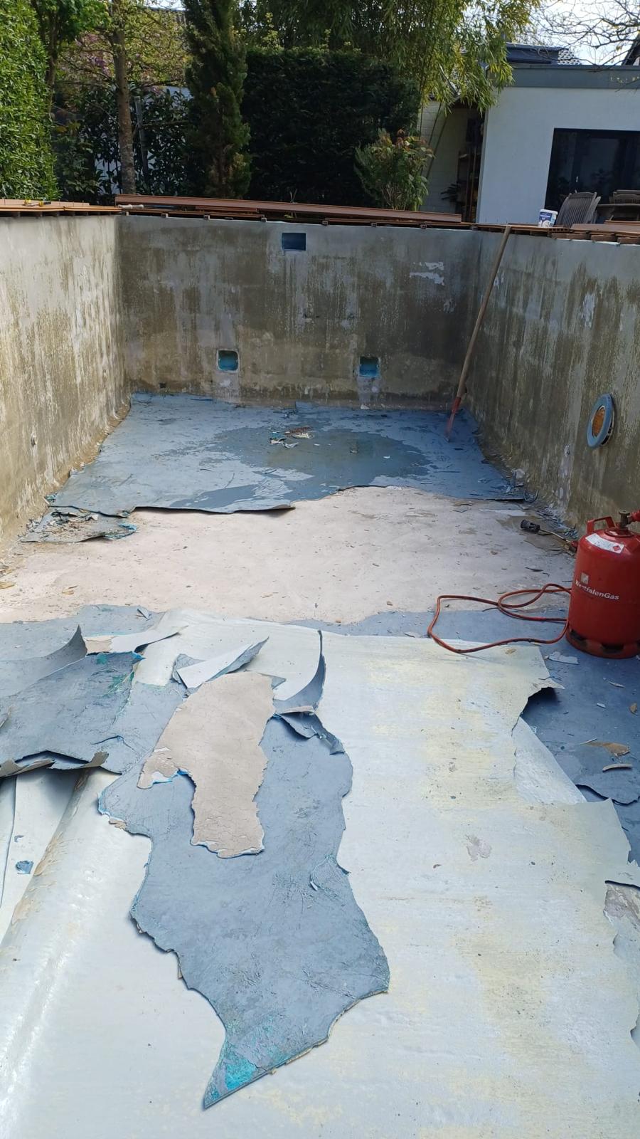 Poolbecken während der Entfernung des alten blauen Belags.