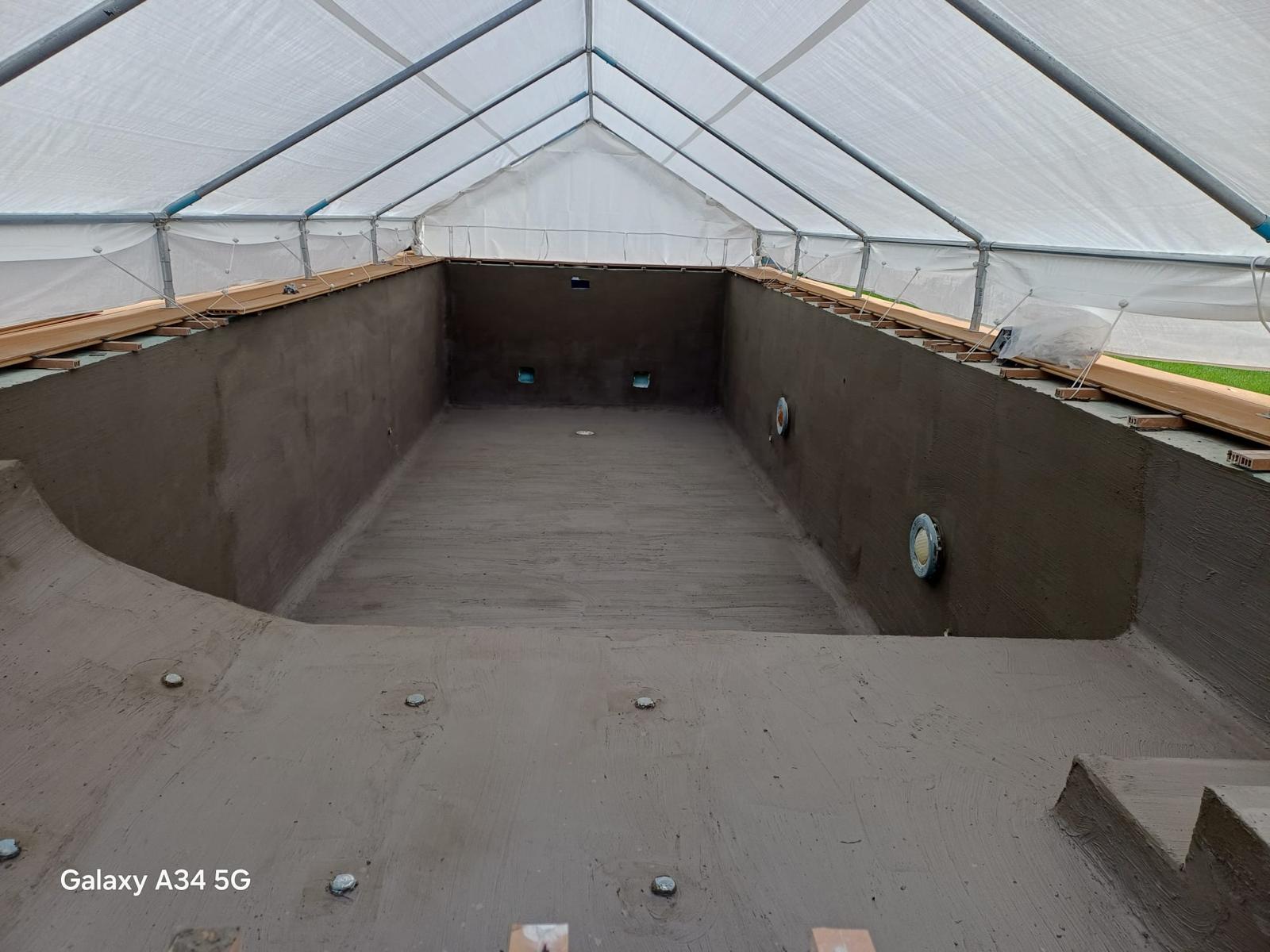 Poolbecken mit grau beschichteten Flächen vor der Mosaikverlegung.